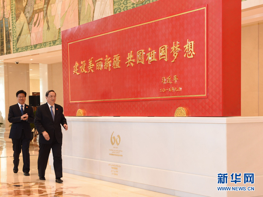 這是俞正聲和中共中央政治局委員、新疆維吾爾自治區(qū)黨委書記張春賢一同為習近平總書記題詞賀匾揭幕。新華社記者 高潔 攝 