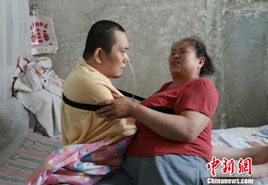 身體日漸衰老的梁青蘭每次幫兒子翻身、坐立，全身的衣物都要濕透一次?！∩忻鱾b 攝