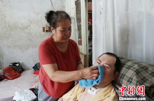 每次喂完食物后，梁青蘭都要仔細地幫兒子清理干凈。　尚明俠 攝