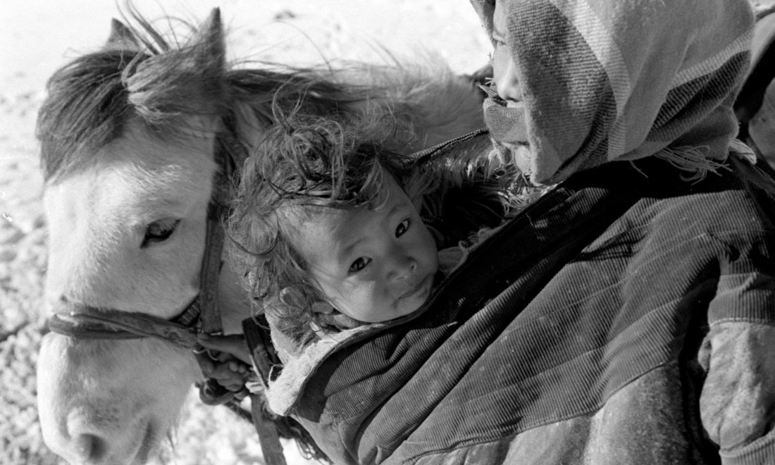 1990年3月，西藏當(dāng)雄縣納木湖鄉(xiāng)三村女牧民斯卓不畏嚴(yán)寒，懷抱幼子，準(zhǔn)備到遠(yuǎn)處放牧。新華社記者覺果攝