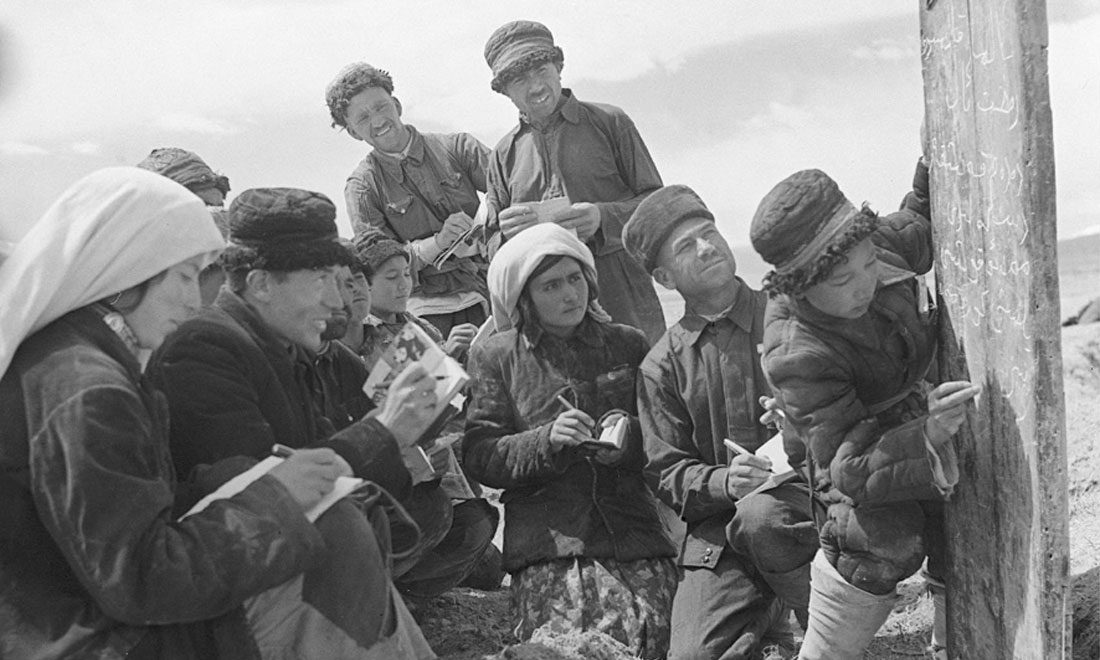 1960年6月，新疆慕士塔格峰下，大人們在小學(xué)生幫助下學(xué)習(xí)文化。新華社記者武純展攝