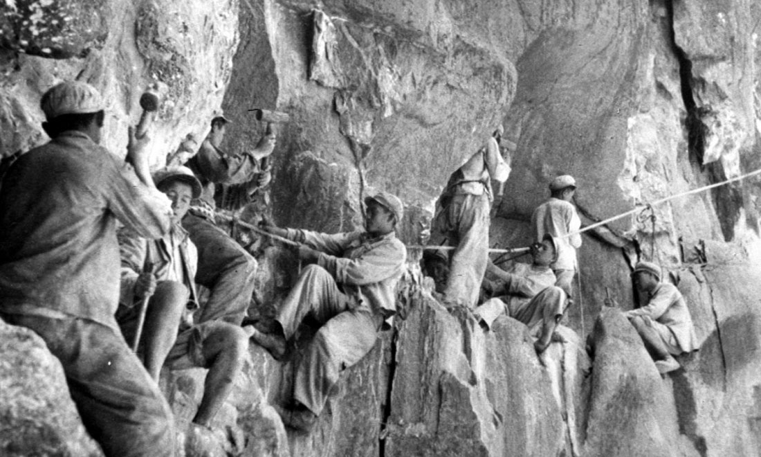 1954年，修筑康藏公路的解放軍戰(zhàn)士們在怒江兩岸的懸崖陡壁上辟山筑路。新華社稿 李萬春、張加里攝
