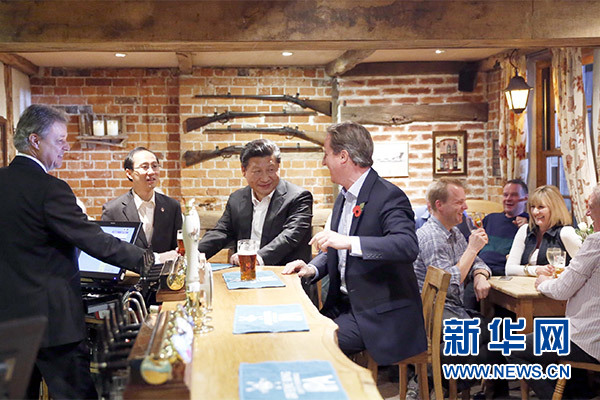 這是會晤結(jié)束后，習(xí)近平在卡梅倫陪同下乘車前往當(dāng)?shù)匦℃?zhèn)體驗(yàn)酒吧文化。新華社記者 鞠鵬 攝